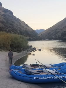 a fisheman walk the shore during sunset on the salmon river in idaho
