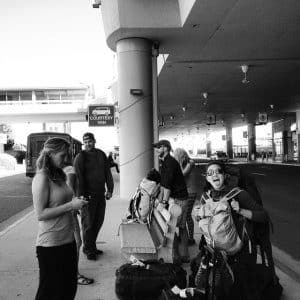 a group of people are acting silly and excited at the boise airport, waiting to get onto a hells canyon adventure