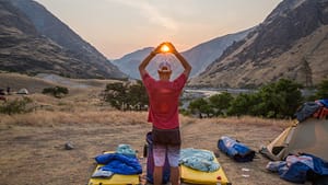 the sun rises behind camp on a hells canyon whitewater rafting trip in idaho