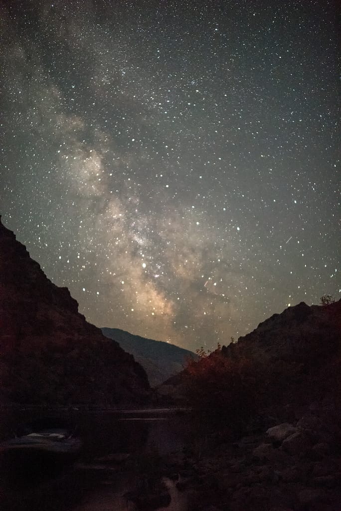 Nighttime sky full of stars against canyon walls during a Hells Canyon Whitewater Rafting Trip on the Snake River