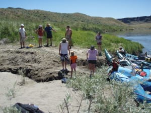 guides tie up the rafts while families get off the boats to enjoy a riverside lunch on a sandy beach on the Salmon river