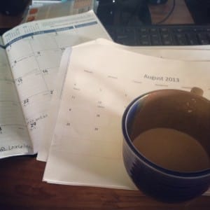 cup of coffee on top of calendars