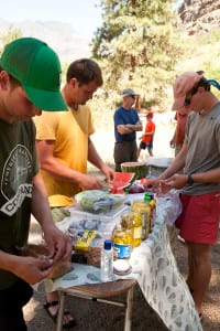 3 guides prepare lunch for the hungry guests on the rafting trip