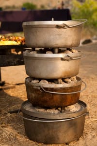 dutch ovens stacked on top of each other while baking cakes and hot reach breads on a multiday rafting trip in idaho