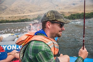 a fisherman gets splashed by a water gun on a whitewater rafting trip in hells canyon