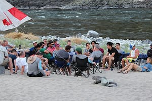 a group has a business meeting on the shores of the salmon river