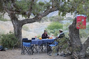 Ladies have appetizers under trees on a Hells Canyon rafting trip
