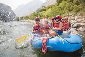 a group in a paddle raft slash the camera man while in hells canyon