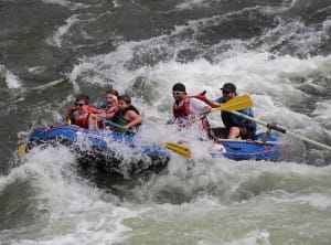 a family filled boat punches through a rapid in hells canyon on the snake river