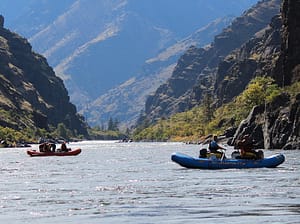 2 boats float down the mellow water of the snake river in hells canyon
