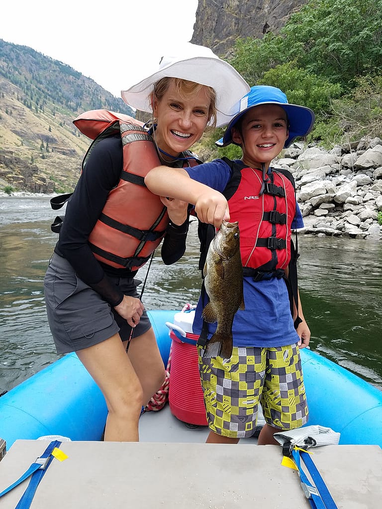 A mom and son pose with a freshly caught fish in Hells Canyon on a Snake River Rafting Trip